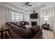 Comfortable living room featuring a fireplace, ceiling fan, and ample natural light from the large windows at 6015 Pleasant Run Dr, Matthews, NC 28104