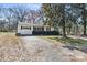 Charming single-story home with a white exterior, black shutters, and mature trees at 629 Johns Ln, Gastonia, NC 28052