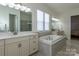 Bright bathroom with a soaking tub, double vanity, and natural light from the many windows at 7133 Sumters Camp Trl, Fort Mill, SC 29707