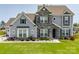 Charming two-story home featuring stone accents, a manicured lawn, and beautiful landscaping at 7133 Sumters Camp Trl, Fort Mill, SC 29707