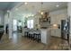 Open kitchen with pendant lighting, white cabinets, a large island with barstool seating, and stainless steel appliances at 7133 Sumters Camp Trl, Fort Mill, SC 29707