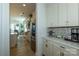 Butler's pantry and kitchen featuring white cabinetry, countertops, mosaic tile backsplash, and modern appliances at 7133 Sumters Camp Trl, Fort Mill, SC 29707