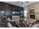 Inviting living room with fireplace, modern ceiling fan, contemporary decorative wall, and comfortable leather seating at 7133 Sumters Camp Trl, Fort Mill, SC 29707