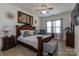 Cozy main bedroom featuring a dark wood bed frame, bench, neutral walls and flooring, and stylish decor at 7133 Sumters Camp Trl, Fort Mill, SC 29707
