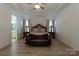 Elegant main bedroom with a tray ceiling, wood-look floors, and sophisticated furnishings at 7133 Sumters Camp Trl, Fort Mill, SC 29707