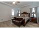 Luxury main bedroom showcases trey ceilings and wood-look flooring, complemented by a sophisticated dark wood bed frame at 7133 Sumters Camp Trl, Fort Mill, SC 29707