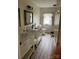 Bright bathroom featuring dual vanities, wood-look tile flooring, and a framed mirror at 730 Jackson Rd, Salisbury, NC 28146