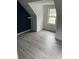 Attic bedroom with blue accent wall, window, and wood-look flooring at 730 Jackson Rd, Salisbury, NC 28146