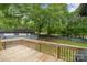 Enjoy a wood deck with a lush green backyard, surrounded by mature trees at 8850 Hills Dell Dr, Concord, NC 28027