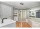Bright bathroom features a soaking tub, glass shower, and updated vanity with storage at 8850 Hills Dell Dr, Concord, NC 28027