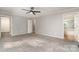 Spacious bedroom featuring neutral walls and gray carpet, illuminated by a modern ceiling fan at 8850 Hills Dell Dr, Concord, NC 28027