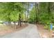 Long driveway leading to a home surrounded by lush trees at 8850 Hills Dell Dr, Concord, NC 28027