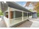 Inviting covered porch with white railings and columns, adding classic charm to the home's facade at 8850 Hills Dell Dr, Concord, NC 28027