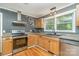 Well-lit kitchen with updated stainless steel appliances and stylish backsplash at 8850 Hills Dell Dr, Concord, NC 28027