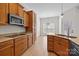 Well-lit kitchen featuring wood cabinetry, granite countertops, and modern appliances at 910 Pine Knoll Rd # 13, Fort Mill, SC 29715