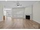 Open-concept living room boasts hardwood floors, a ceiling fan, and a cozy fireplace at 910 Pine Knoll Rd # 13, Fort Mill, SC 29715