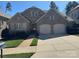 Charming brick and stone home with a two-car garage and well-manicured front yard and walkway at 9218 Robbins Preserve Rd, Cornelius, NC 28031
