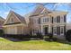 Charming two-story brick home with a lush green lawn and manicured landscaping on a sunny day at 9433 Wallace Pond Dr, Huntersville, NC 28078