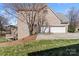 Brick home featuring a two-car garage and additional exterior staircase and landscaping with green grass at 9433 Wallace Pond Dr, Huntersville, NC 28078