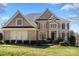 Charming two-story brick home with a lush green lawn and manicured landscaping at 9433 Wallace Pond Dr, Huntersville, NC 28078