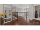Bright hallway featuring hardwood floors, wrought iron railing, and a view of the home's interior at 9433 Wallace Pond Dr, Huntersville, NC 28078