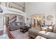 Open-concept living room with high ceilings, hardwood floors, a fireplace, and easy access to the staircase and kitchen area at 9433 Wallace Pond Dr, Huntersville, NC 28078