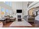 Bright living room with soaring ceilings, a fireplace, built-in shelving, hardwood floors, and lots of comfortable seating at 9433 Wallace Pond Dr, Huntersville, NC 28078