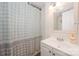 Bright bathroom with a patterned shower curtain, a white vanity, and a well-lit mirror at 9937 Harwood Ln, Charlotte, NC 28214