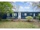 The exterior of the home has a small fenced porch and is surrounded by trees and a green yard at 9937 Harwood Ln, Charlotte, NC 28214