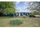 Blue single-story home with a star on the front door and white railing, surrounded by large trees and a big front yard at 9937 Harwood Ln, Charlotte, NC 28214