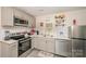 Efficient kitchen space with appliances, white cabinets and drawers with gray hardware at 9937 Harwood Ln, Charlotte, NC 28214