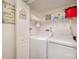 Well-organized laundry room featuring a side-by-side washer and dryer with shelving for storage at 9937 Harwood Ln, Charlotte, NC 28214