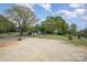 Large lot featuring a house with a basketball court and spacious gravel parking area at 9937 Harwood Ln, Charlotte, NC 28214