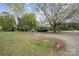 Spacious yard showcasing the home's exterior, with mature trees and ample open space at 9937 Harwood Ln, Charlotte, NC 28214