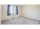 Bedroom with carpet flooring, neutral walls, and a window with blue curtains at 1022 Kannapolis Pkwy, Concord, NC 28027