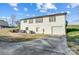 Rear view of a two-story home with white siding, dark shutters, attached garage and a grassy area at 1022 Kannapolis Pkwy, Concord, NC 28027