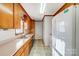 Functional kitchen featuring double bowl sink, wood cabinets, and white appliances at 1022 Kannapolis Pkwy, Concord, NC 28027