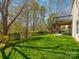 Lush backyard with green grass, mature trees, and a view of the home's deck and lower patio at 1033 Ridge Haven Rd, Waxhaw, NC 28173
