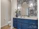 Stylish powder room with blue vanity, modern fixtures, and patterned wallpaper at 1033 Ridge Haven Rd, Waxhaw, NC 28173