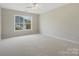 Spacious bedroom featuring neutral carpeting, a ceiling fan, and natural light from a large window at 1033 Ridge Haven Rd, Waxhaw, NC 28173