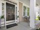 Inviting covered front porch with black front door, white trim, and seating area at 1033 Ridge Haven Rd, Waxhaw, NC 28173