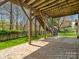 View of the patio with stone flooring and wooded backyard providing a private outdoor living space at 1033 Ridge Haven Rd, Waxhaw, NC 28173