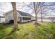 Serene backyard with mature trees, a screened porch, and a lush lawn offers a peaceful outdoor retreat at 108 Vermillion Loop, Statesville, NC 28625