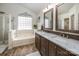 Bathroom with double vanity, tiled floor, glass block window, and bathtub with shower at 108 Vermillion Loop, Statesville, NC 28625