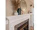 Close up of fireplace mantel with white vase, round mirror, and accent pieces at 108 Vermillion Loop, Statesville, NC 28625