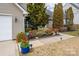 Landscaped walkway with colorful flowers, leading to a home with vinyl siding at 108 Vermillion Loop, Statesville, NC 28625