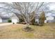 Landscaped home with mature trees, vinyl siding, and an attached two-car garage at 108 Vermillion Loop, Statesville, NC 28625