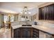 Kitchen island with stainless steel sink and view to the eating nook with a fireplace at 108 Vermillion Loop, Statesville, NC 28625
