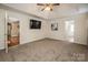 A carpeted main bedroom featuring a tray ceiling, ceiling fan, and two doors at 108 Vermillion Loop, Statesville, NC 28625