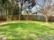 Grassy backyard enclosed by a wooden fence with several trees lining the perimeter at 12044 Brownestone View Dr, Charlotte, NC 28269